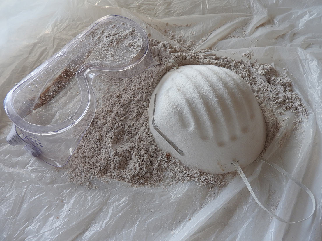 goggles and mask on top of a pile of asbestos